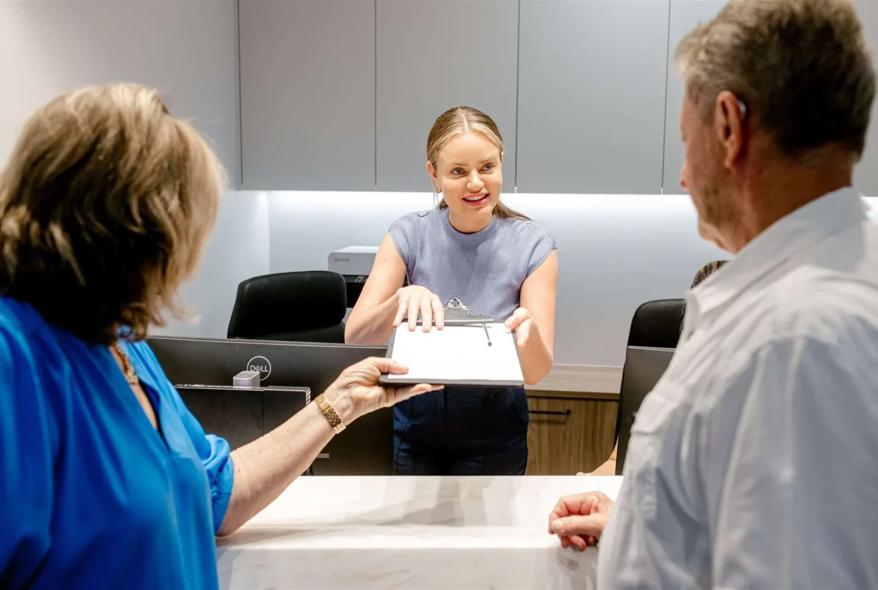 Clinic manager assisting patient with forms completion