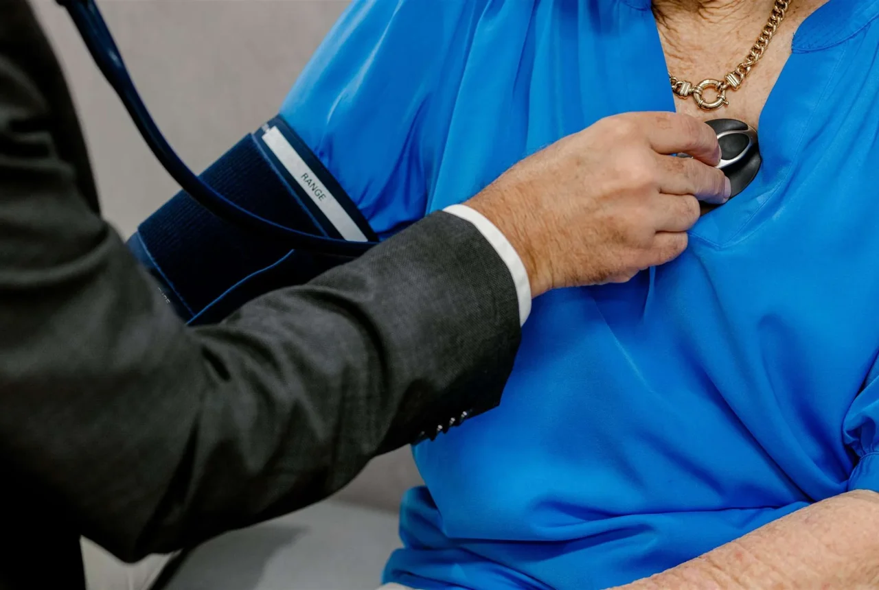 A close-up view of Dr Hadjipetrou listening to a patient's heart with a stethoscope