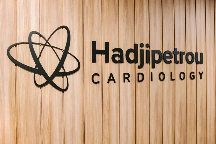 View of Dr Hadjipetrou's branding logo on the clinic's wooden wall